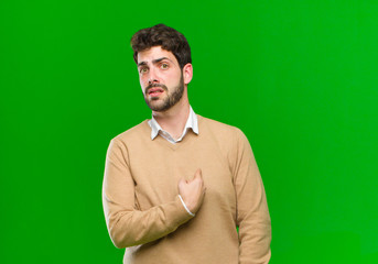 young businessman feeling confused, puzzled and insecure, pointing to self wondering and asking...