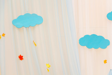 blue clouds are made of paper surrounded by yellow leaves. Autumn concept.