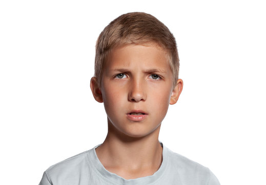 Close-up portrait of a blonde teenage boy in a white t-shirt posing isolated on white studio background. Concept of sincere emotions.