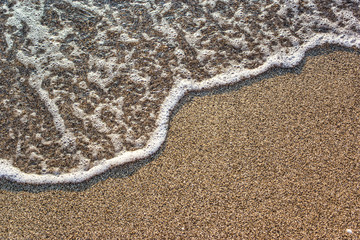 Fototapeta na wymiar Close-up of sandy beach with soft waves