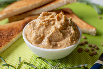 Hummus in a bowl on the table with a green napkin and croutons