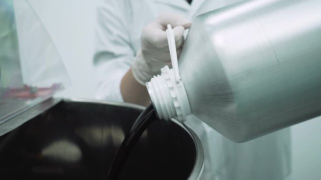 Close look of Scientist filling container with CBD oil in Hemp Cbd laboratory