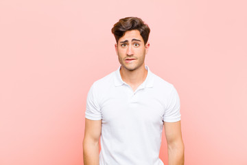 young handsome man feeling clueless, confused and uncertain about which option to pick, trying to...