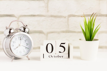 the fifth of October on the wooden calendar next to the alarm clock, the fifth day of the second autumn month