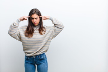 young pretty woman with a serious and concentrated look, brainstorming and thinking about a...