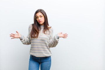 young pretty woman feeling puzzled and confused, unsure about the correct answer or decision,...