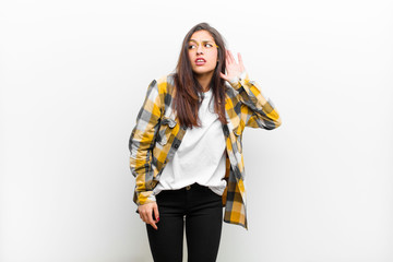 young pretty woman looking serious and curious, listening, trying to hear a secret conversation or...