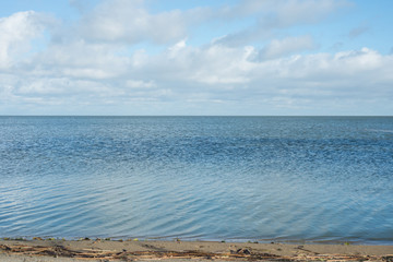  Sea shore with blue water, clouds