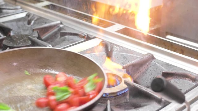 Cottura in padella di un ristorante di pomodori e basilico per la pasta italiana