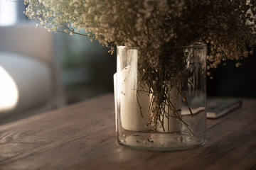Detail composition of Dried Gypso flower in glass vase setting on vintage brown wood coffee table/scandinavian interior design decoration/modern nordic style / winter  theme