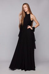 Full shot of young blonde European lady with long straight hair in a black chiffon sleeveless...