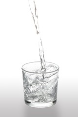 water flow filling a glass on white background