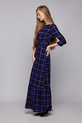 Full shot of a blonde European lady with long hair in a black maxi dress with a print Scottish...