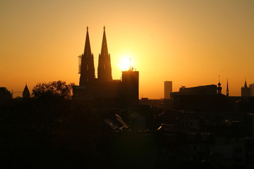 Obraz premium Early morning view over the historical part of Cologne, Germany. Silhouette of Cologne Cathedral (German: Kölner Dom). Bright orange sunrise.