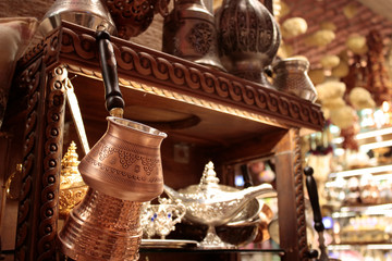 Coffee pot in front of store close-up in background. There are bowls and pitchers.