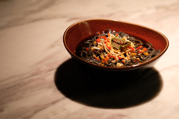 close up a dish of Hot and Sour Fern Root Noodles on restaurant table. Traditional Chinese cuisine