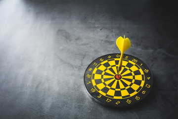 Dart board with yellow arrows hitting target, closeup.