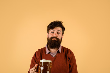 Celebration oktoberfest festival. Handsome man drinks ale at bar or pub. Beard man drinking beer from mug. Lager and dark ale. Beer time. Bearded man holds beer glass. Young man tasting draft beer.