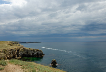 Speedboat in the sea at the rocky shore.