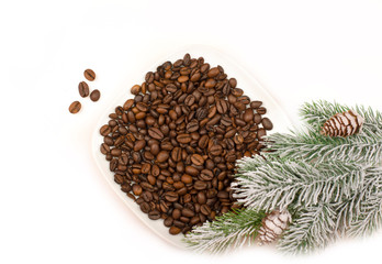 Coffee beans. Green needles. New Year. Christmas. Christmas tree branches with coffee beans on a white surface.Copy space for text.