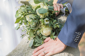wedding bouquet and hands with rings of groom and bride