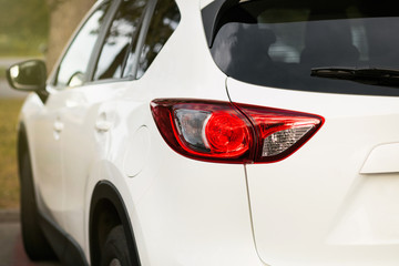 Back view of new white car. Closeup headlights of car. White premium city crossover, luxury SUV...