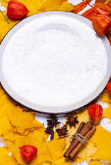 White ceramic plate on an autumn leaf background.