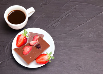 coffee and strawberries with chocolate on the table