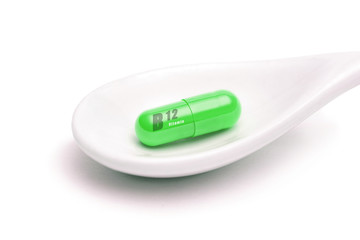 Isolated spoon with vitamin b12 on white background. Pharmacy, medicine concept. Taking medications and pills. Vitamins and minerals for health