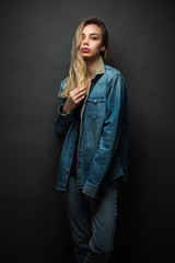 Sexy blonde girl wearing jeans clothes over gray background