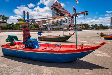 Local fishing boat moored on the beach at low tide in Prachuap Khiri Khan Province, Thailand