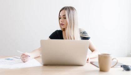 Pretty business freelancer woman working on her computer. Girl at her workspace. Start-up office background