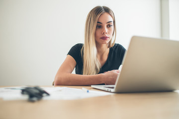 Pretty business freelancer woman working on her computer. Girl at her workspace. Start-up office background