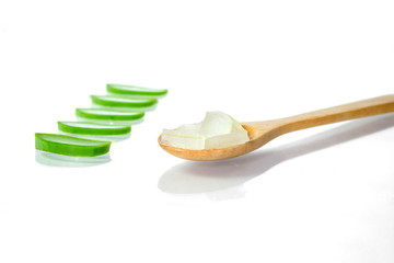 Aloe vera fresh leaves with slices and gel on wooden spoon on white background.