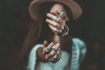 Boho schicke Frau mit Strohhut in einer weißen kurzen Bluse und mit silbernem Türkisschmuck. Boho-Mode. Hippie-Stil, stilvolles Mädchen mit silbernen Ringen © Goffkein