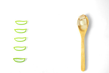 Aloe vera fresh leaves with slices and gel on wooden spoon on white background.