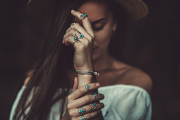 Boho chic woman in a straw hat in a white short blouse and with silver turquoise jewelry. Boho...