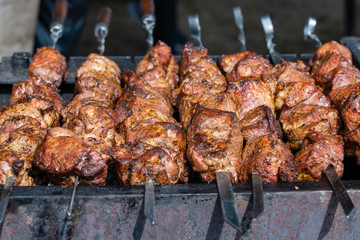 Grilled kebab cooking on metal skewer closeup. Roasted meat cooked at barbecue. BBQ fresh beef meat chop slices. Traditional eastern dish, shish kebab