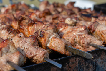 Grilled kebab cooking on metal skewer closeup. Roasted meat cooked at barbecue. BBQ fresh beef meat chop slices. Traditional eastern dish, shish kebab
