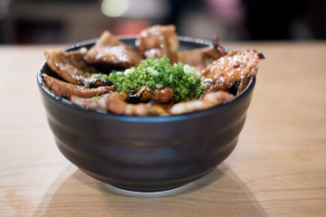 Butadon in bowl of rice topped with sliced pork and sweet sauce