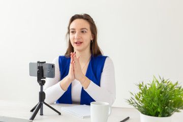 Blogging, broadcast and people concept - woman blogger is talking to the camera for her spectators