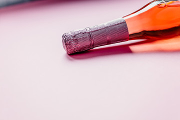Bottle of rose champagne wine on pink background