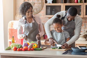 Close family of three cooking together at home