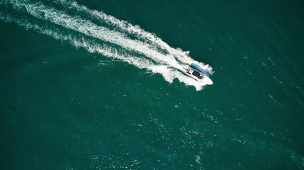 Yachts at the sea surface. Aerial view of luxury floating boat on blue Adriatic sea. Speed boat or in motion
