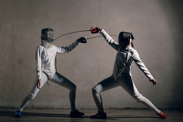 Fencer woman with fencing sword. Fencers duel concept.