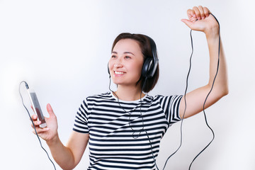 young smiling asian woman listening music from earphone and dance