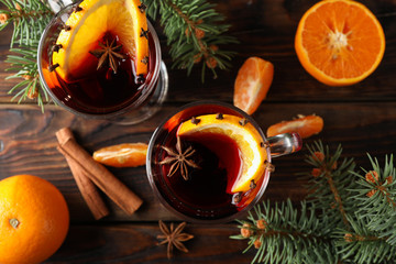 Glasses of tasty mulled wine with orange on wooden background, top view