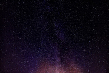 Photograph of the night sky in the mountains, with a view of the Milky Way. Visible stars, galaxy, universe.