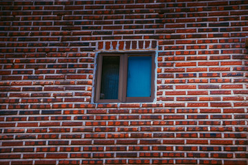 Winow in the middle of the red brick wall.