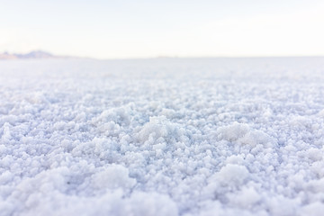 Macro closeup low angle ground level view on texture of Bonneville salt flats with wet salt on...